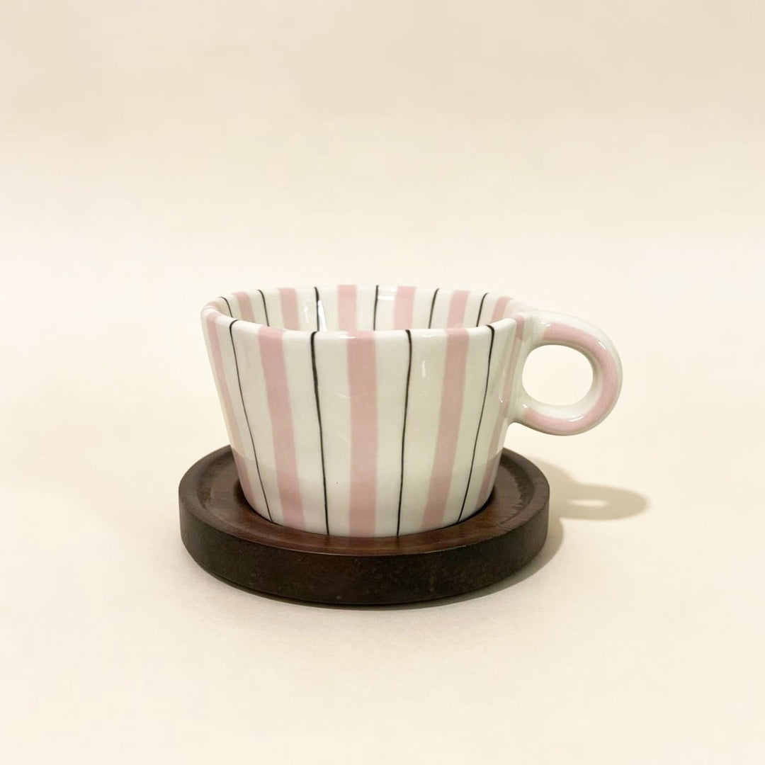 Ceramic espresso cup with round wooden coaster and handcrafted stripe pattern