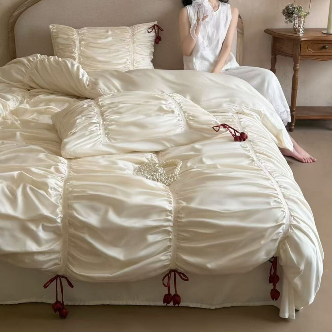 Satin bedding set with gathered drawstring look and tassels