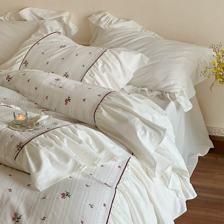Cotton muslin bedding set with embroidered striped relief, gathered ruffle and fine piping