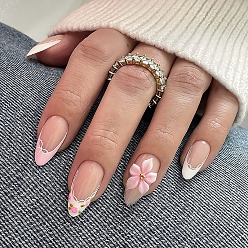 Artful nail extensions with delicate floral pattern and elegant accents Kalsten