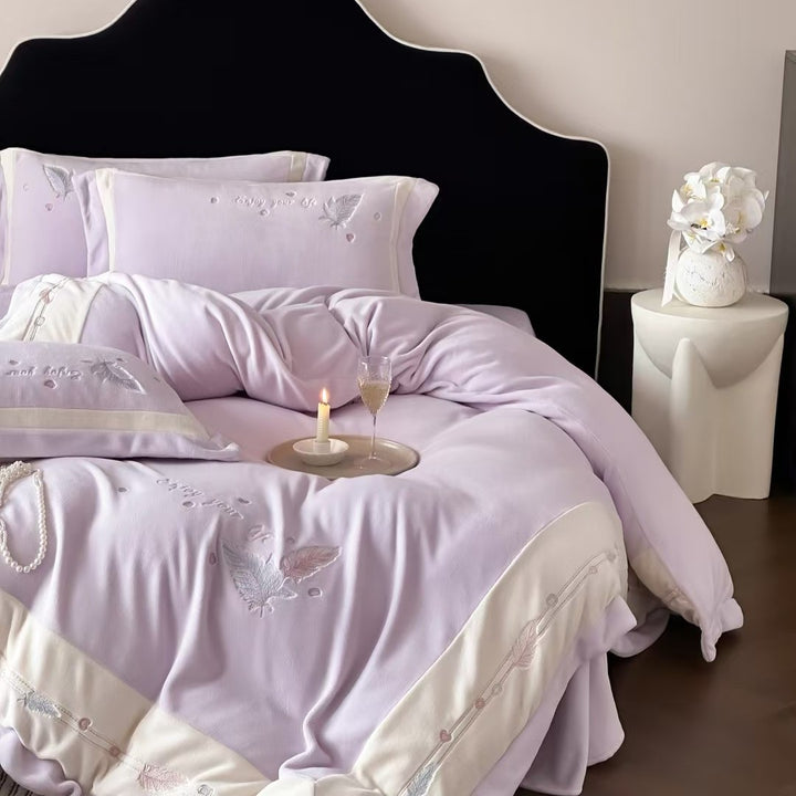 Luxurious bedding set with embroidered feather motifs and quilted bedspread
