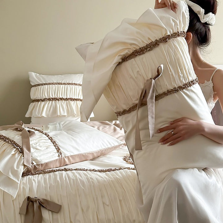Pleated bed linen set with ruffle, decorative ribbons and bow accents