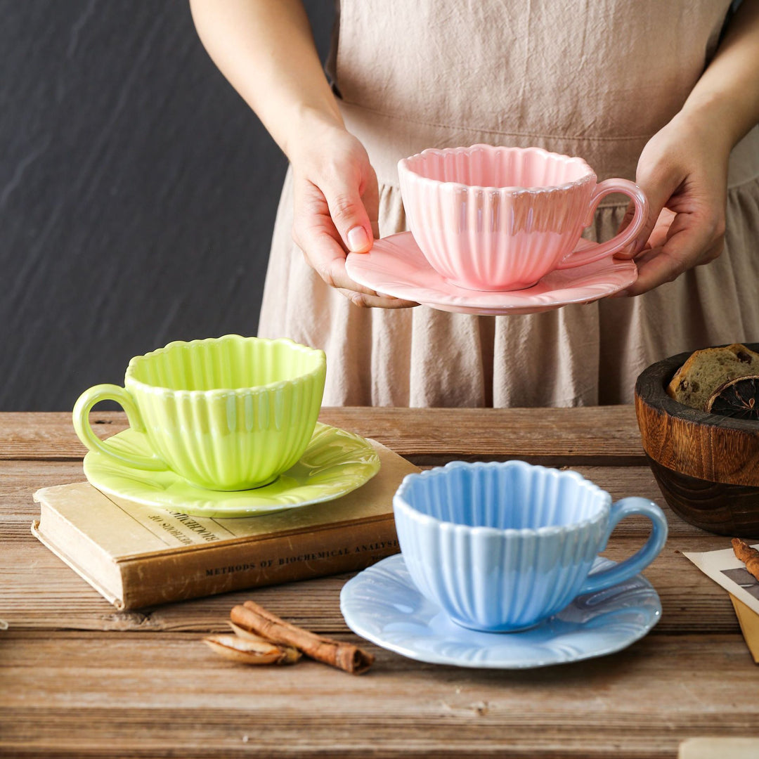 Fine porcelain tea cup with ribbed shell shape and matching saucer