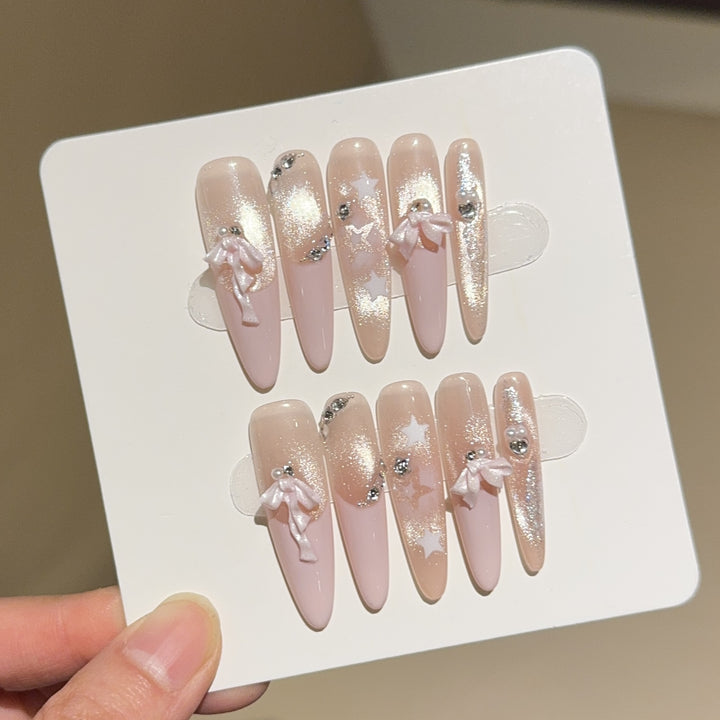 Artificial nail tips with glamorous glitter and bow details Kalsten