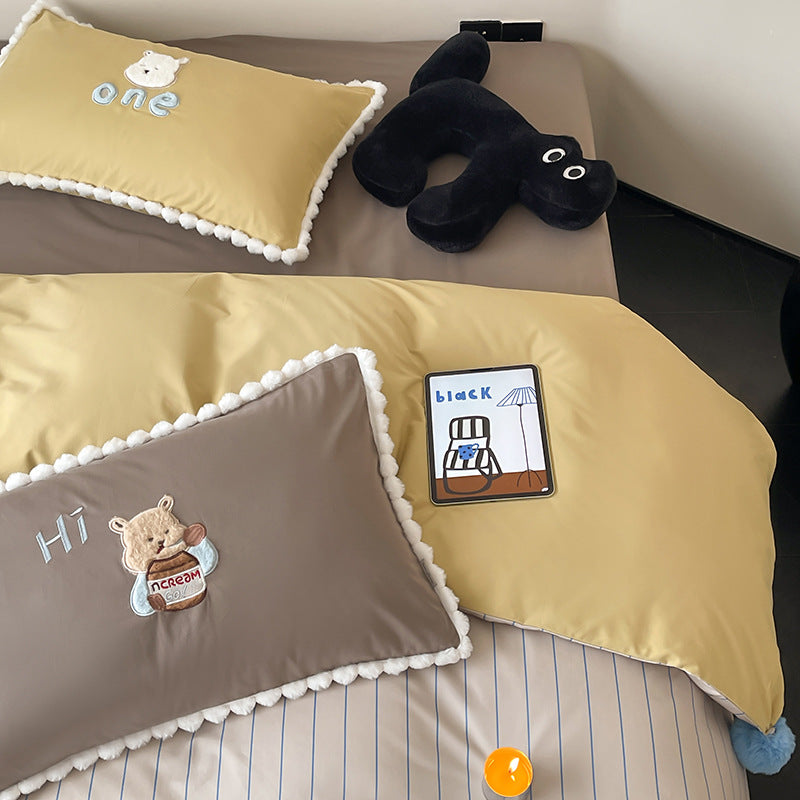 Children's bed set with teddy bear embroidery, pom-pom edging, and reversible blanket