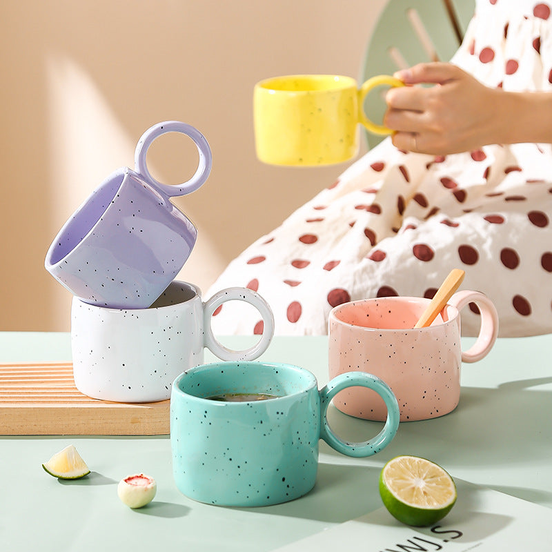 Ceramic mug with heart-shaped handle and speckle design