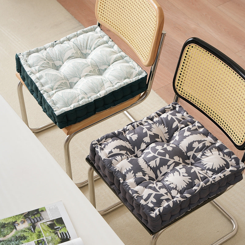 Padded floor cushion with quilted tufting, floral motif and carrying handle