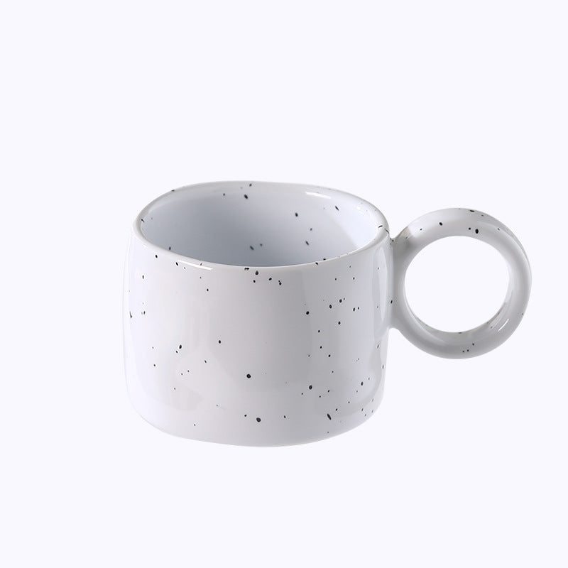 Ceramic mug with heart-shaped handle and speckle design