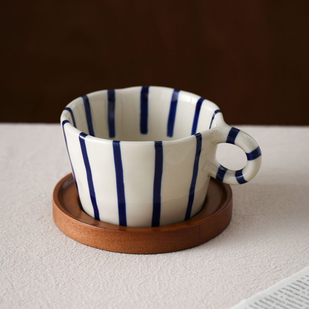 Ceramic espresso cup with round wooden coaster and handcrafted stripe pattern