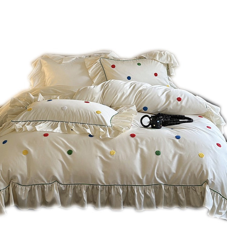 Bedding set with embroidered dots, decorative ruffles, and fine piping