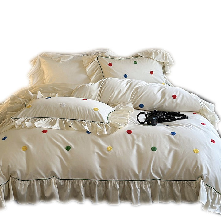 Bedding set with embroidered dots, decorative ruffles, and fine piping