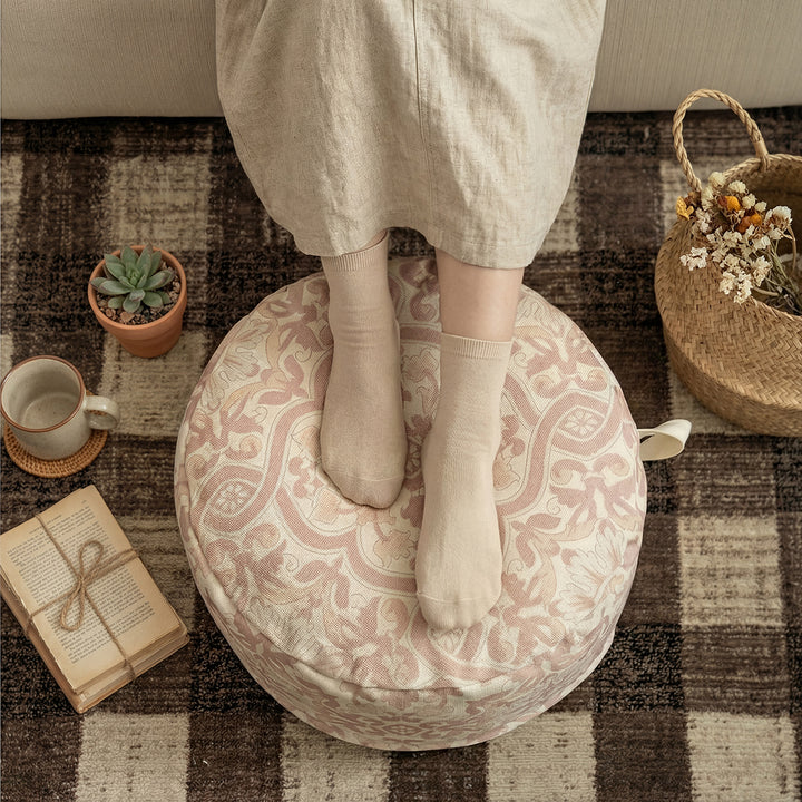 Round floor pouf with woven ornament pattern and carrying handle Kalsten
