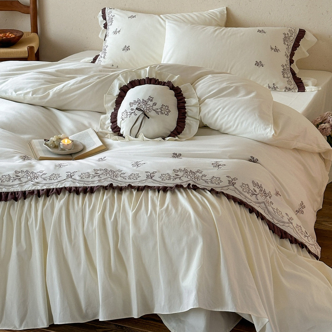 Luxurious bedding set with embroidered cover, ruffled bed skirt, and decorative pillow