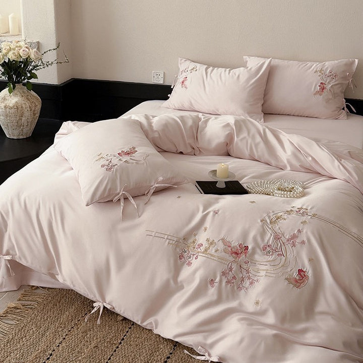 Satin bedding set with floral embroidery, ribbon ties and silky surface