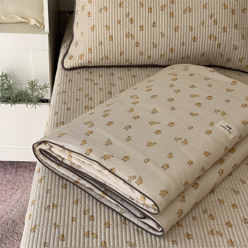 Padded children's bed pad and play mat made of quilted cotton with duck print