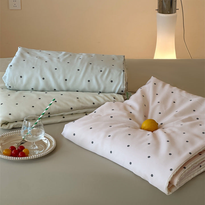 Luxurious satin bedding set with polka dot pattern and pom-pom tassels