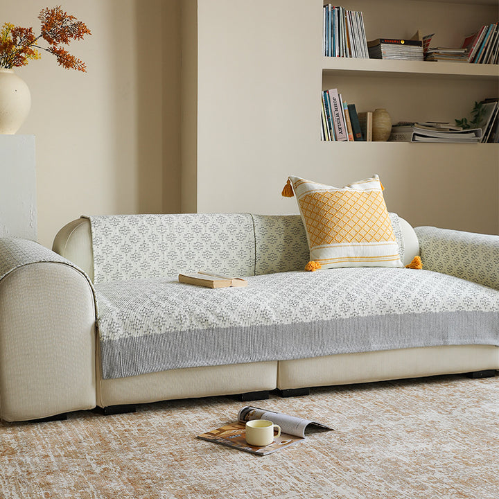 Knitted sofa cover with jacquard pattern and reinforced hem border Kalsten