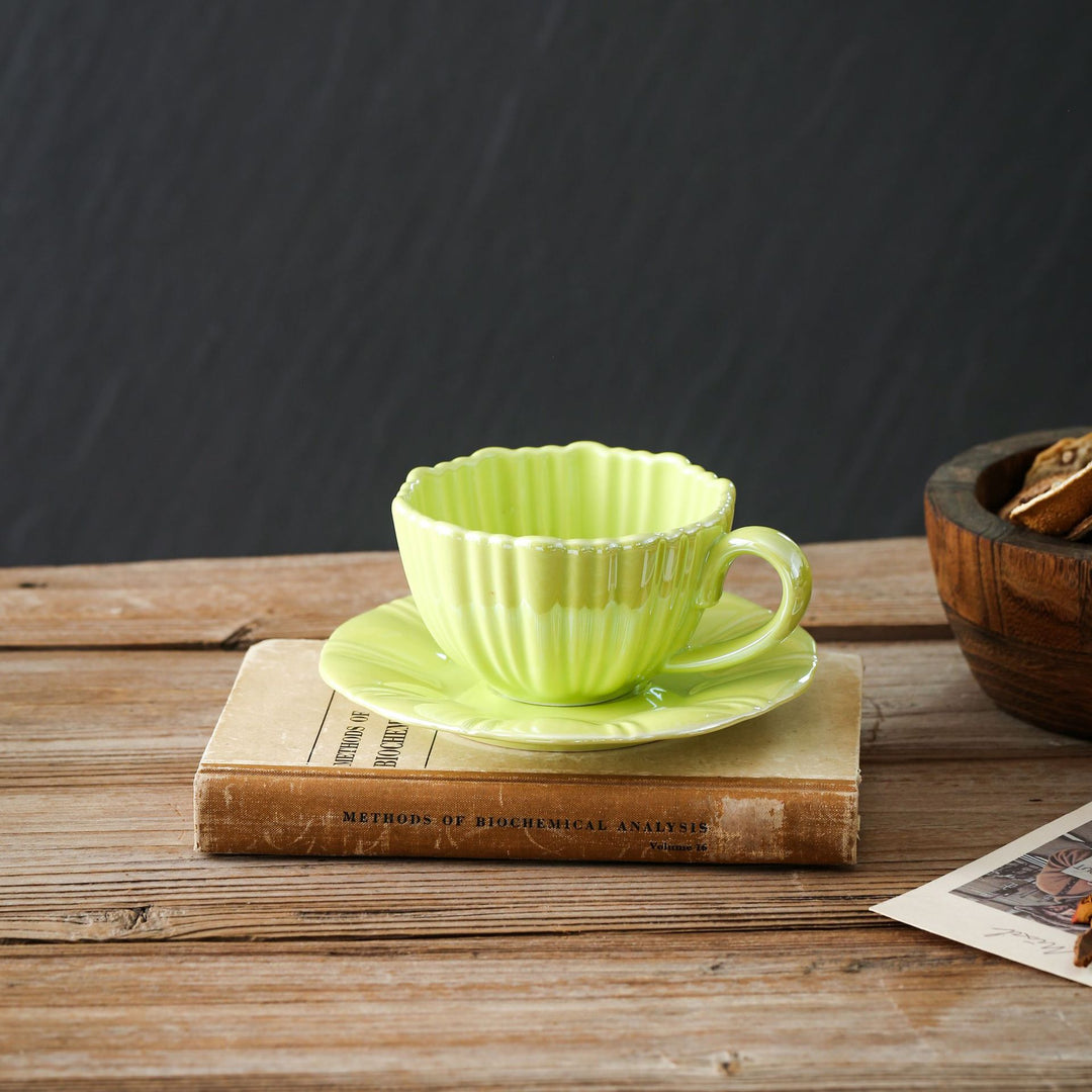 Fine porcelain tea cup with ribbed shell shape and matching saucer
