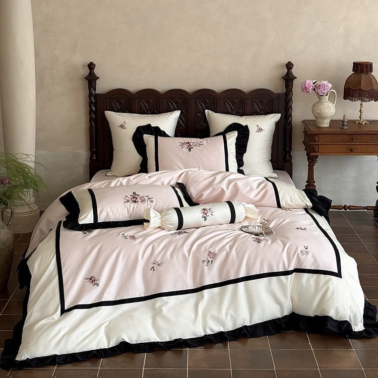 Luxurious embroidered bed linen set made of cotton satin with ruffles and decorative pillows