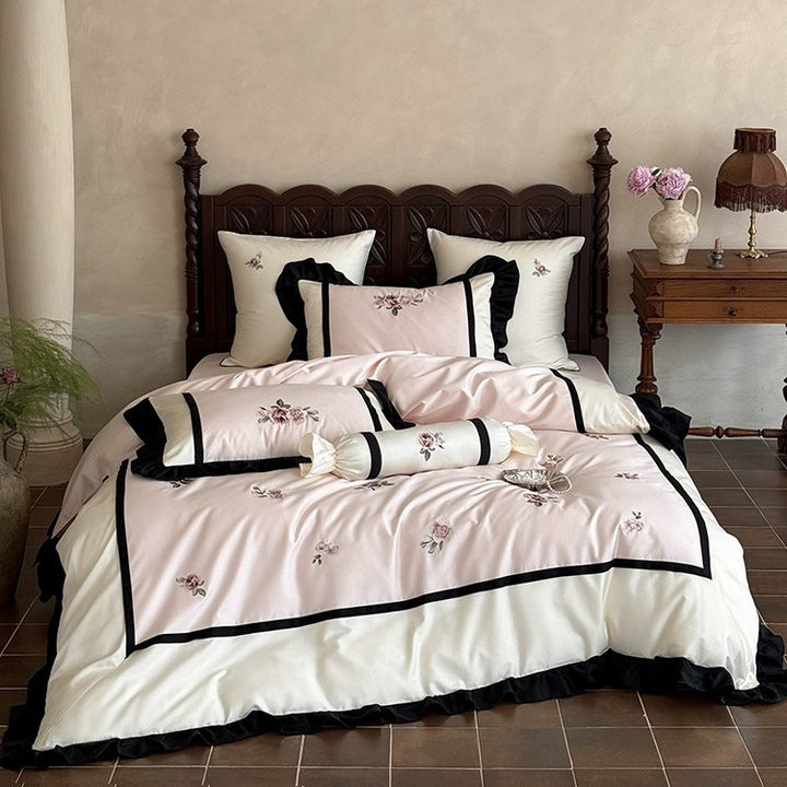 Luxurious embroidered bed linen set made of cotton satin with ruffles and decorative pillows