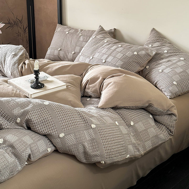 Luxurious cotton bedding set with textured waffle appearance and pompom details