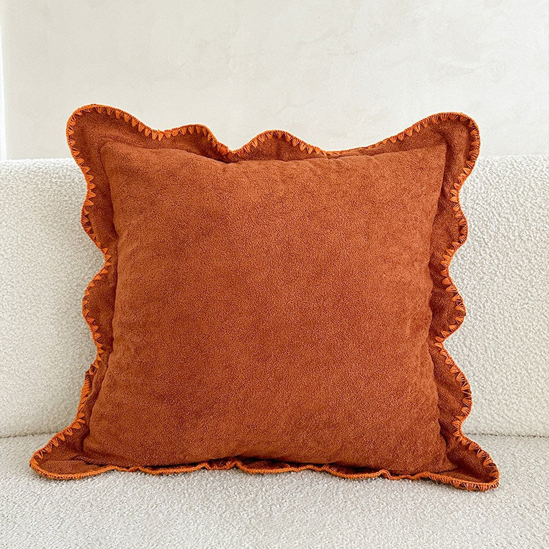 Decorative velvet cushion with wavy edge and decorative stitching