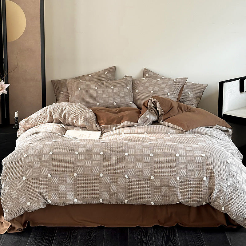 Luxurious cotton bedding set with textured waffle appearance and pompom details