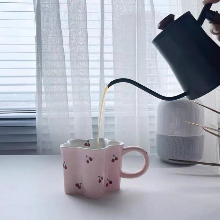 Ceramic coffee mug with flower-shaped wavy rim, illustrative banana decor and ergonomic handle