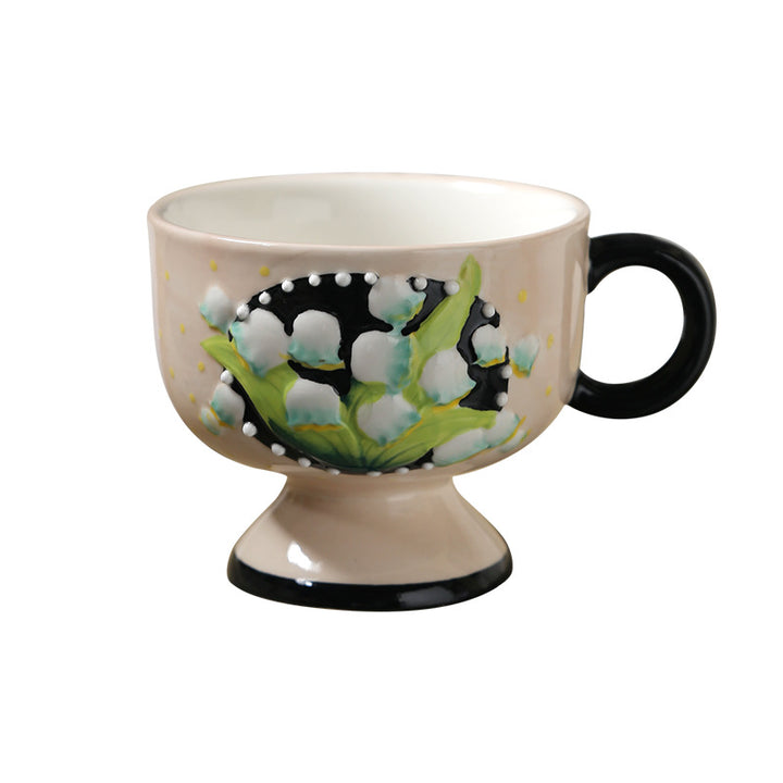 Ceramic foot cup with hand-painted lily of the valley relief and round handle