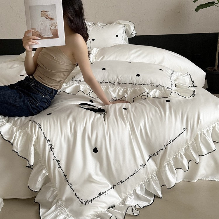 Luxurious cotton satin bedding set with ruffled trim, embroidered heart motifs, and calligraphic writing