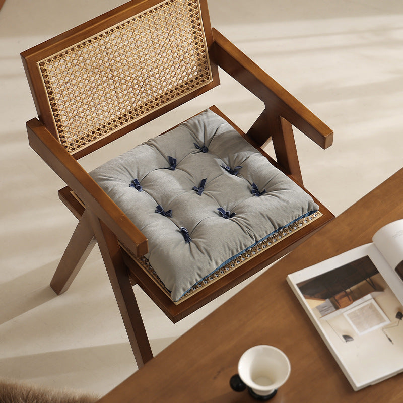 Padded upholstered chair cushion with quilting and fastening straps