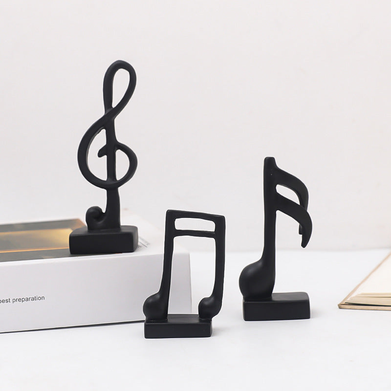 Three music note figures, resin, modern